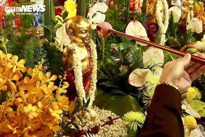 Từng dòng nước thơm được rót nhẹ nhàng lên tượng Phật sơ sinh, biểu trưng cho sự gột rửa tâm hồn, từ bỏ tham - sân - si, nuôi dưỡng tâm từ bi và hướng thiện. (Ảnh: Đắc Huy)