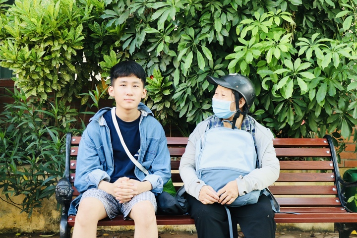 Chị Phạm Thị Hòa và con trai có mặt sớm nhất tại điểm trường THPT Đại Mỗ (phường Đại Mỗ).