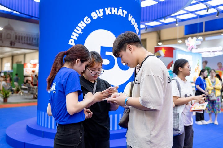 Khách tham quan tương tác tại khu vực “trái tim phụng sự” để khám phá câu chuyện 50 năm của Vinamilk. (Ảnh: Duy Cường)