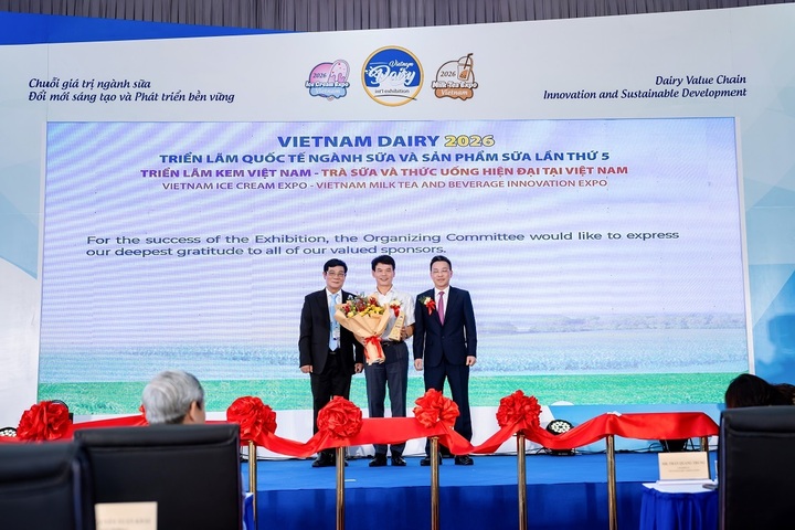 Ông Phạm Tuyên – Giám đốc chi nhánh Vinamilk Hà Nội (áo trắng) – nhận hoa và kỷ niệm chương của Ban tổ chức. (Ảnh: Duy Cường)