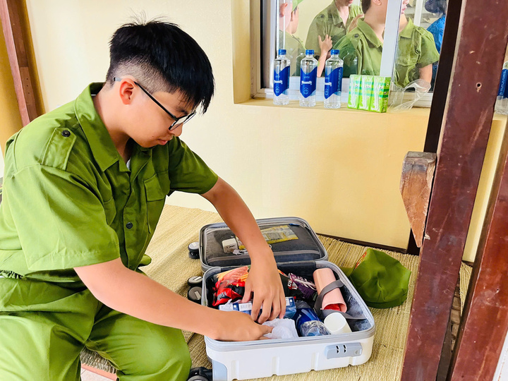 Phúc Khang học cách tự xắp xếp đồ dùng trong ngày đầu tham gia “Học làm chiến sĩ công an”. (Ảnh: VN)