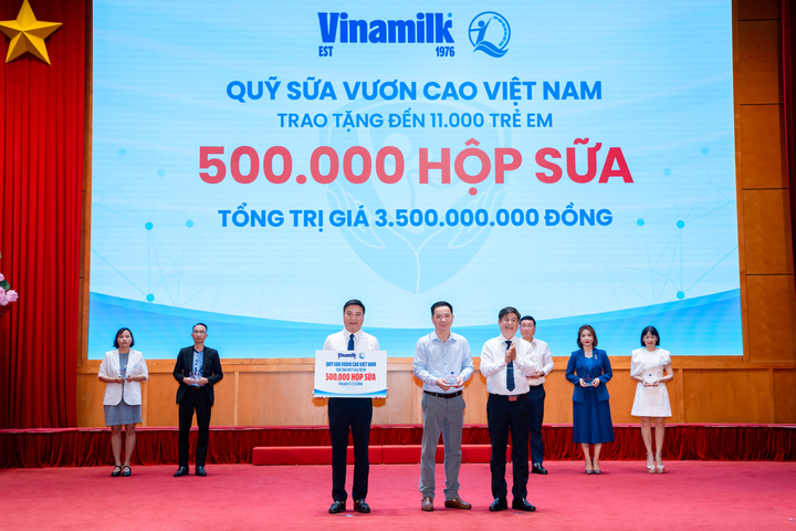 Đại diện Vinamilk (đứng giữa) trao bảng tượng trưng 500.000 hộp sữa và nhận kỷ niệm chương từ Bộ Y tế. (Ảnh: VN)