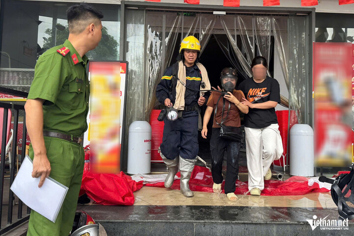 Lực lượng chức năng đưa được 4 người mắc kẹt trong nhà ra ngoài. (Ảnh: Đình Hiếu)