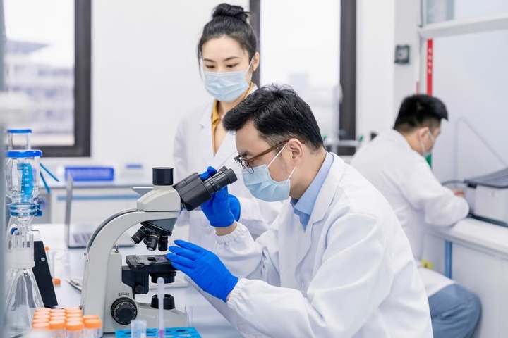 Các nhà khoa học đang sử dụng kính hiển vi và ống nghiệm để nghiên cứu. (Ảnh: Getty Images)