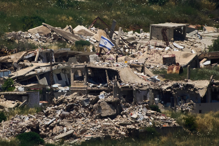 Cờ Israel được cắm trên một toà nhà bị phá huỷ ở miền Nam Lebanon. (Ảnh: AP)