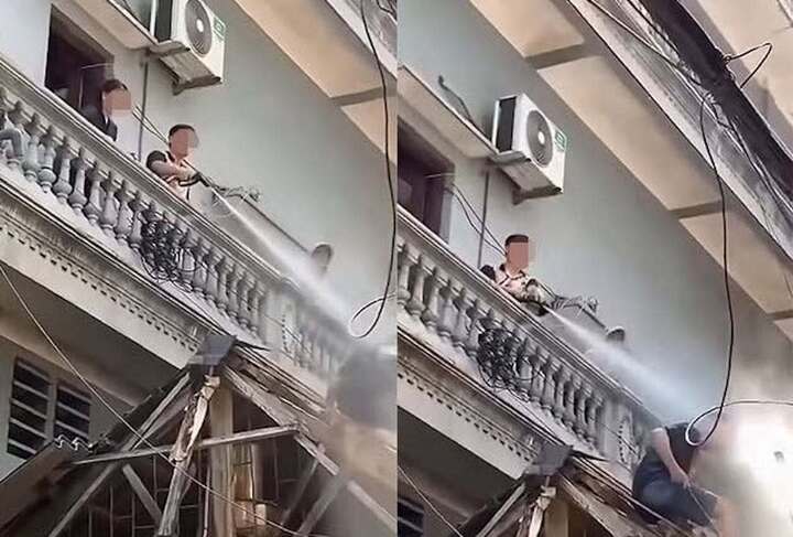 Hình ảnh người đàn ông xịt nước vào thợ đang thi công. (Ảnh cắt từ clip)