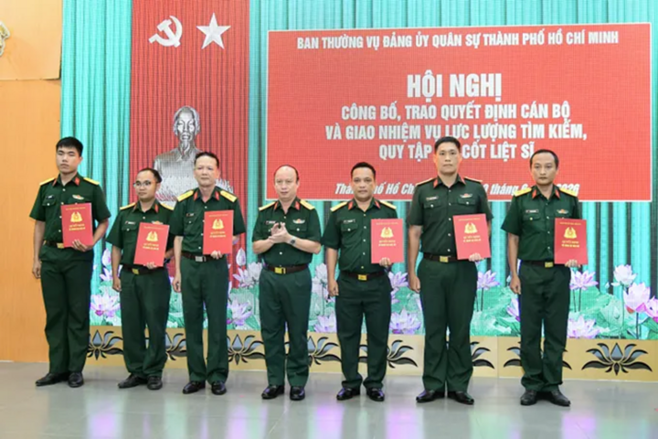 Đại tá Nguyễn Đình Chuẩn, Phó Chính ủy Bộ Tư lệnh TP.HCM trao quyết định điều động, bổ nhiệm cho 6 đồng chí tham gia lực lượng tìm kiếm, quy tập hài cốt liệt sĩ. (Ảnh: Hữu Tân)