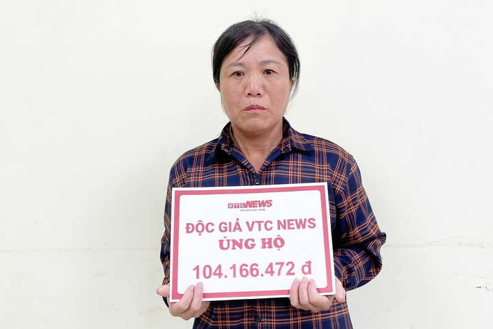 Bà Nguyễn Thị Mầu - mẹ của Huy đón nhận số tiền bạn đọc giúp đỡ. (Ảnh: Khắc Việt)