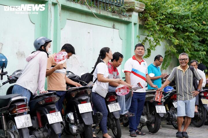 Các phụ huynh chở con tới trường thi sớm, đứng đợi ở khu vực đối diện điểm thi Trưng Vương.