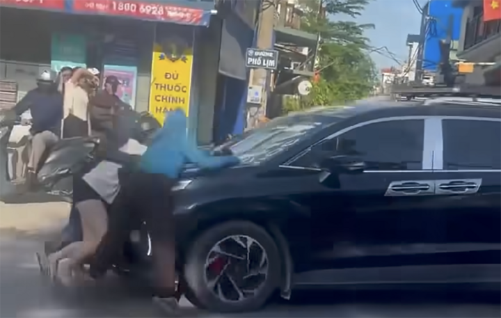 Ba người phụ nữ đu bám trên nắp capo ô tô. (Ảnh cắt từ clip)