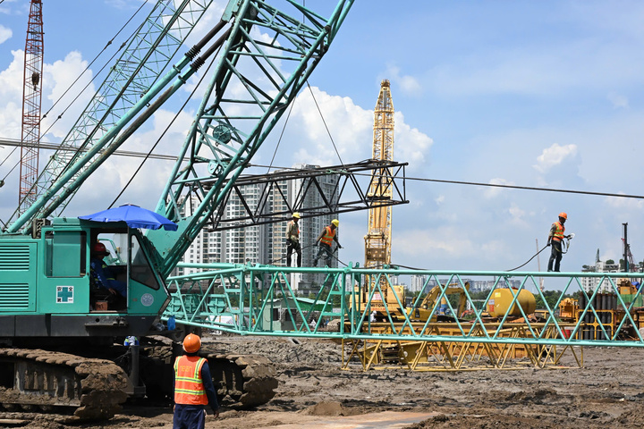 Công nhân và người lao động khẩn trương thi công trên công trường. (Ảnh: Việt Dũng)