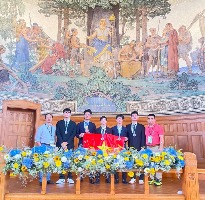 Đội Việt Nam với 5 học sinh xuất sắc giành 1 huy chương Vàng và 4 huy chương Bạc, cùng thầy trưởng đoàn (áo hồng) và thầy phó đoàn (áo xanh). (Ảnh: Trưởng đoàn cung cấp)