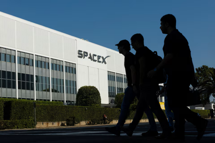Các nhân viên của SpaceX băng qua đường khi họ đến làm việc tại cơ sở SpaceX ở Hawthorne, Mỹ vào ngày công ty niêm yết cổ phiếu. (Nguồn: Reuters)