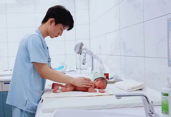 Zhang chăm sóc một em bé sơ sinh trong bệnh viện. (Ảnh: Weixin)