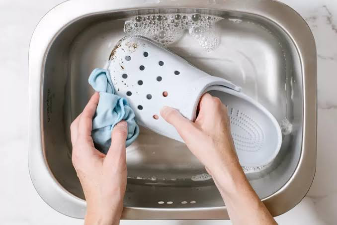 Sử dụng nước ấm và xà phòng vệ sinh thường xuyên sẽ giúp tăng tuổi thọ của đôi Crocs. (Ảnh: HowTo)