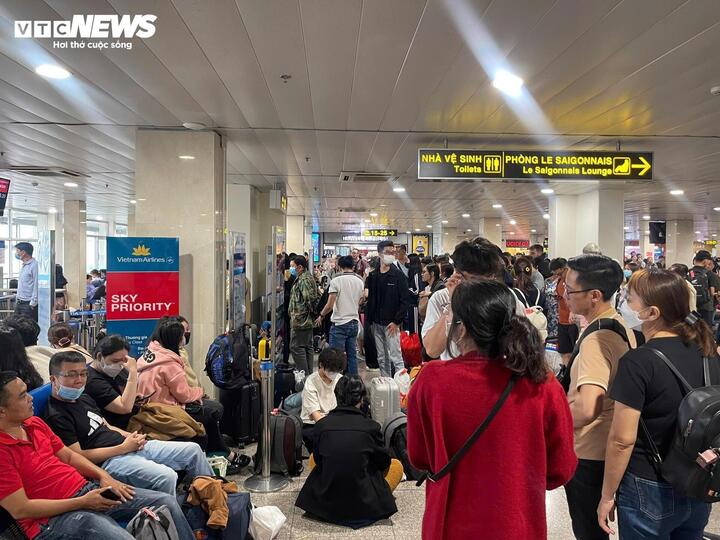 Khách nằm, ngồi vạ vật ở sân bay Tân Sơn Nhất vì bị delay. (Ảnh: Lương Ý)