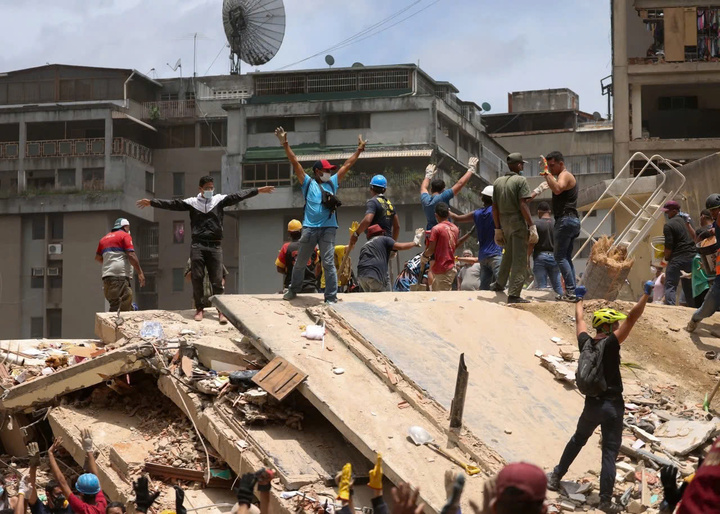 Người dân ra hiệu khi tìm kiếm những người bị thương giữa đống đổ nát. (Ảnh: Reuters)