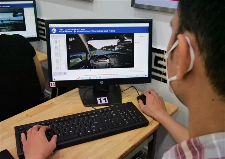 Thí sinh thực hiện bài thi mô phỏng tình huống giao thông trên máy tính. (Ảnh: Anh Tú)