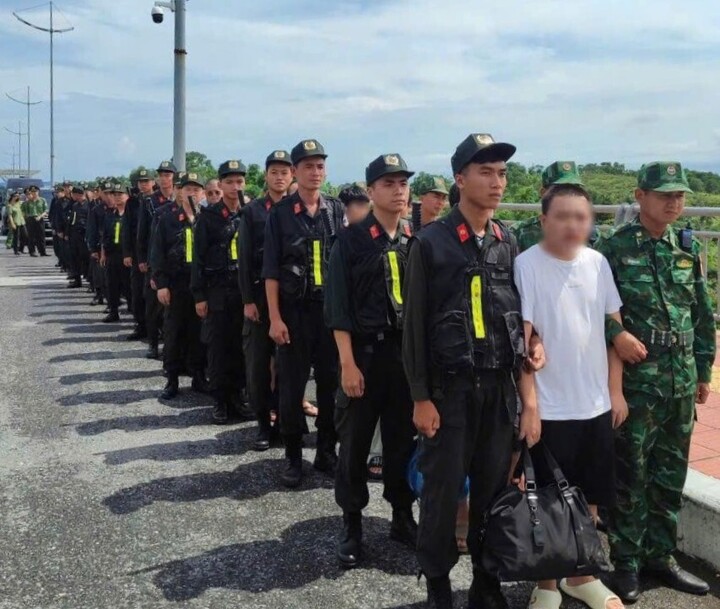 Cơ quan chức năng thực hiện thủ tục chuẩn bị bàn giao 30 người nước ngoài thuộc ổ nhóm tội phạm xuyên biên giới cho Công an Trung Quốc. (Ảnh: Trần Quang)