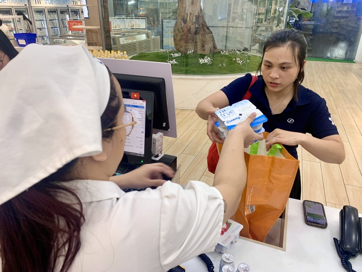 Chị Đỗ Thị Ngân sử dụng túi sinh thái thay thế túi dùng một lần khi mua sắm tại cửa hàng TH true mart 34 Hoàng Quốc Việt - Hà Nội.