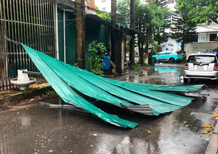 Mái tôn nhà dân bị gió giật văng xuống đường.