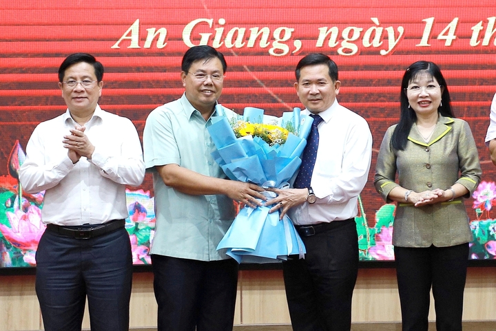 Bí thư Tỉnh ủy An Giang Nguyễn Tiến Hải (thứ 2 từ trái qua) tặng hoa chúc mừng ông Đinh Văn Nơi. (Ảnh: Huy Nhật).