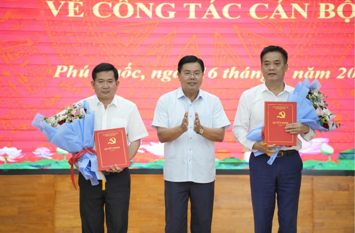 Bí thư Tỉnh ủy An Giang Nguyễn Tiến Hải trao quyết định của Ban Thường vụ Tỉnh ủy và tặng hoa chúc mừng ông Đinh Văn Nơi (trái) và ông Lê Quốc Anh.