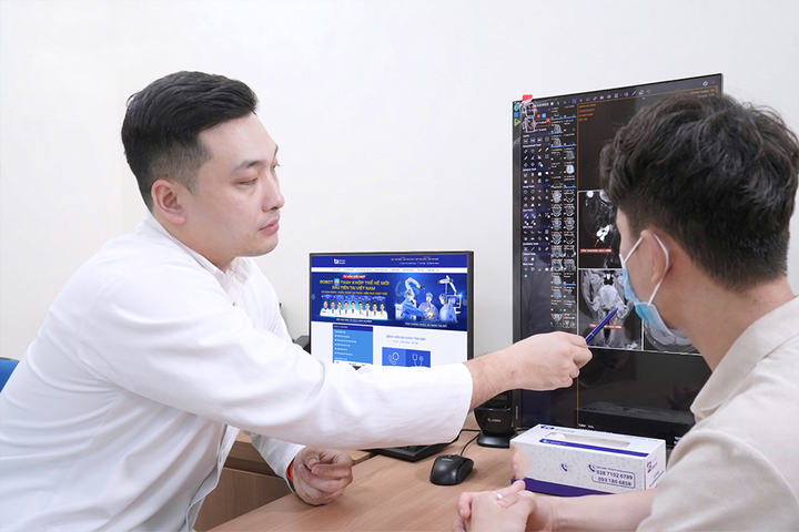 Bác sĩ Trung đang đọc kết quả thăm khám cho người bệnh. (Ảnh: Bệnh viện Đa khoa Tâm Anh)