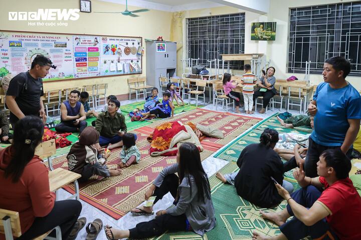 Người lớn quây quần hỏi thăm nhau sau biến cố, còn những đứa trẻ dần lấy lại sự hồn nhiên khi cùng nhau vui chơi trong sân trường.