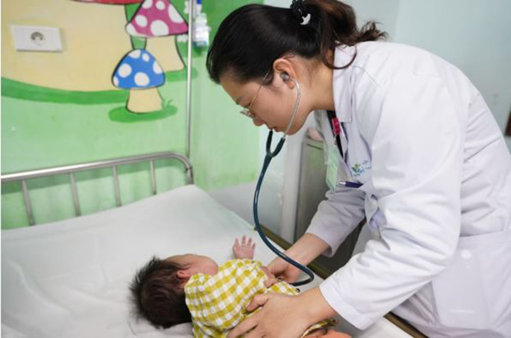 Bác sĩ thăm khám cho bệnh nhi sau phẫu thuật.