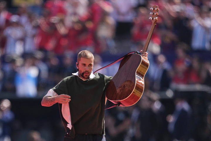 Justin Bieber vừa ôm guitar vừa trình bày phiên bản acoustic của "Everything Hallelujah". (Ảnh: AP)
