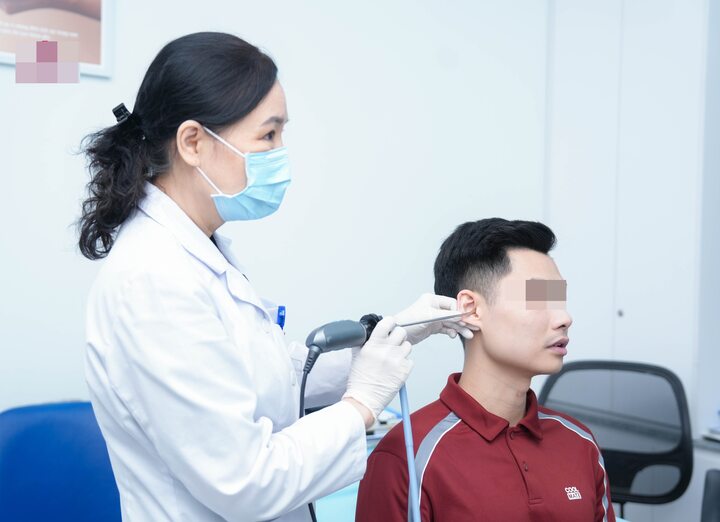 PGS Nguyễn Hoài An kiểm tra thính lực cho người bệnh. (Ảnh: BSCC)