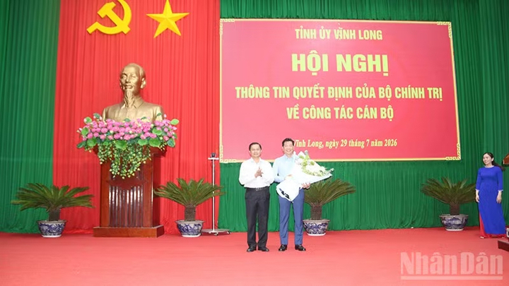Ông Nguyễn Mạnh Hùng nhận hoa chúc mừng của đồng chí Trần Văn Lâu, Ủy viên Trung ương Đảng, Bí thư Tỉnh ủy Vĩnh Long.