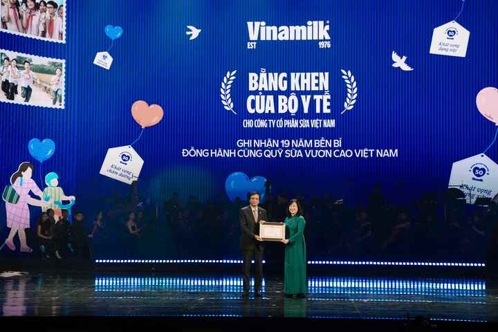 Ông Nguyễn Hạnh Phúc, Chủ tịch Hội đồng Quản trị Vinamilk, đón nhận Bằng khen của Bộ Y tế từ Bộ trưởng Đào Hồng Lan tại chương trình nghệ thuật đặc biệt “50 năm - Phụng sự khát vọng Việt”. (Ảnh: Minh Anh)