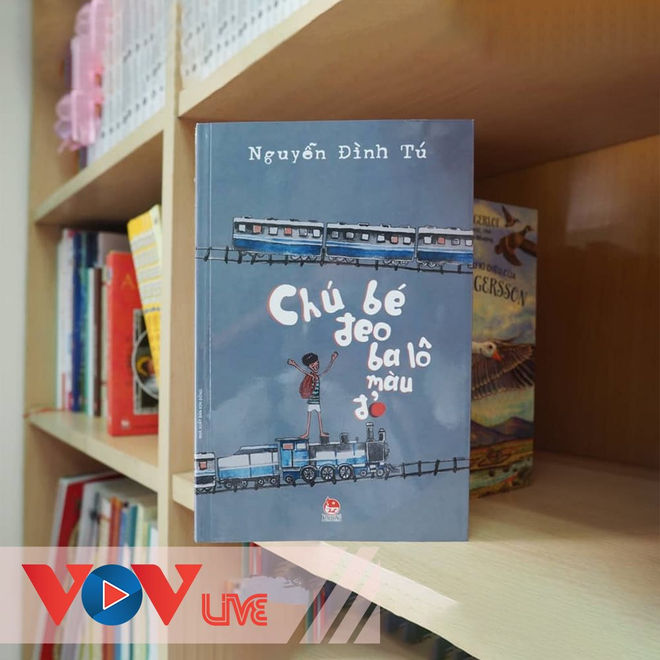 Chú bé đeo ba lô màu đỏ