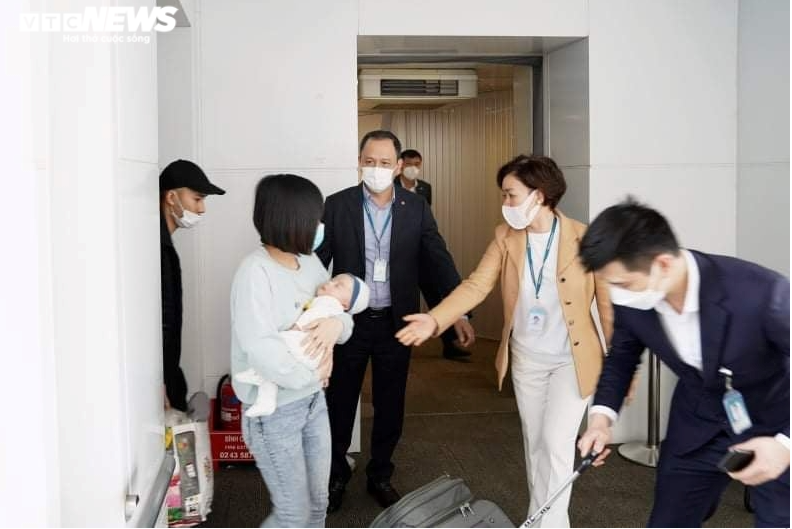 Các nhân viên sân bay hướng dẫn nhóm người Việt sau khi máy bay hạ cánh.