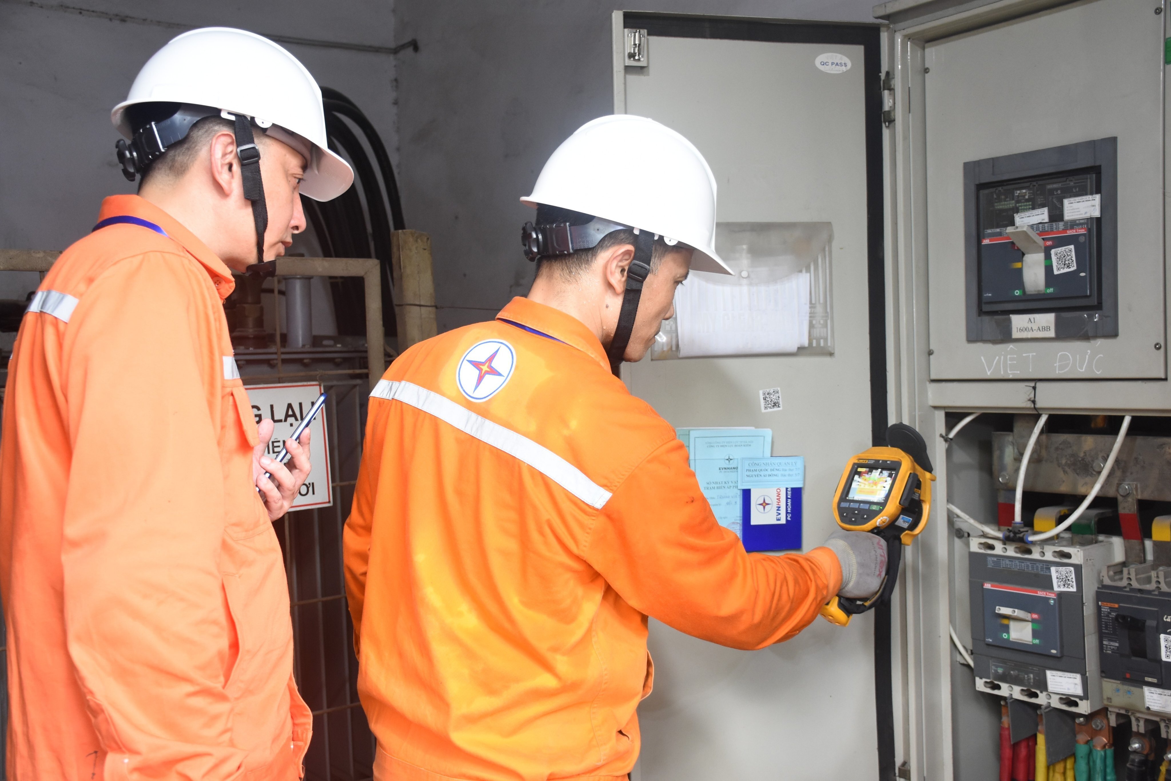 Công nhân Công ty Điện lực Hoàn Kiếm kiểm tra nhiệt độ tại trạm biến áp Trường THPT Việt Đức.