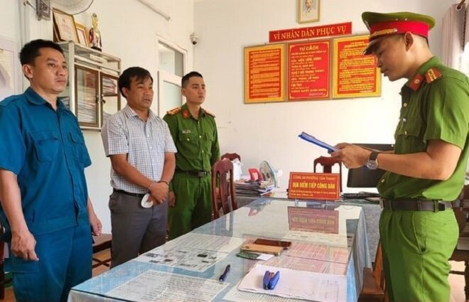 Lực lượng chức năng đọc quyết định khởi tố Nguyễn Thành Trung. (Ảnh: C.A)