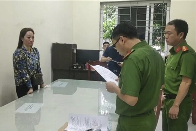 Cơ quan CSĐT Công an thị xã Kinh Môn đọc lệnh bắt giữ Trương Thị Hương. (Ảnh: CAND).