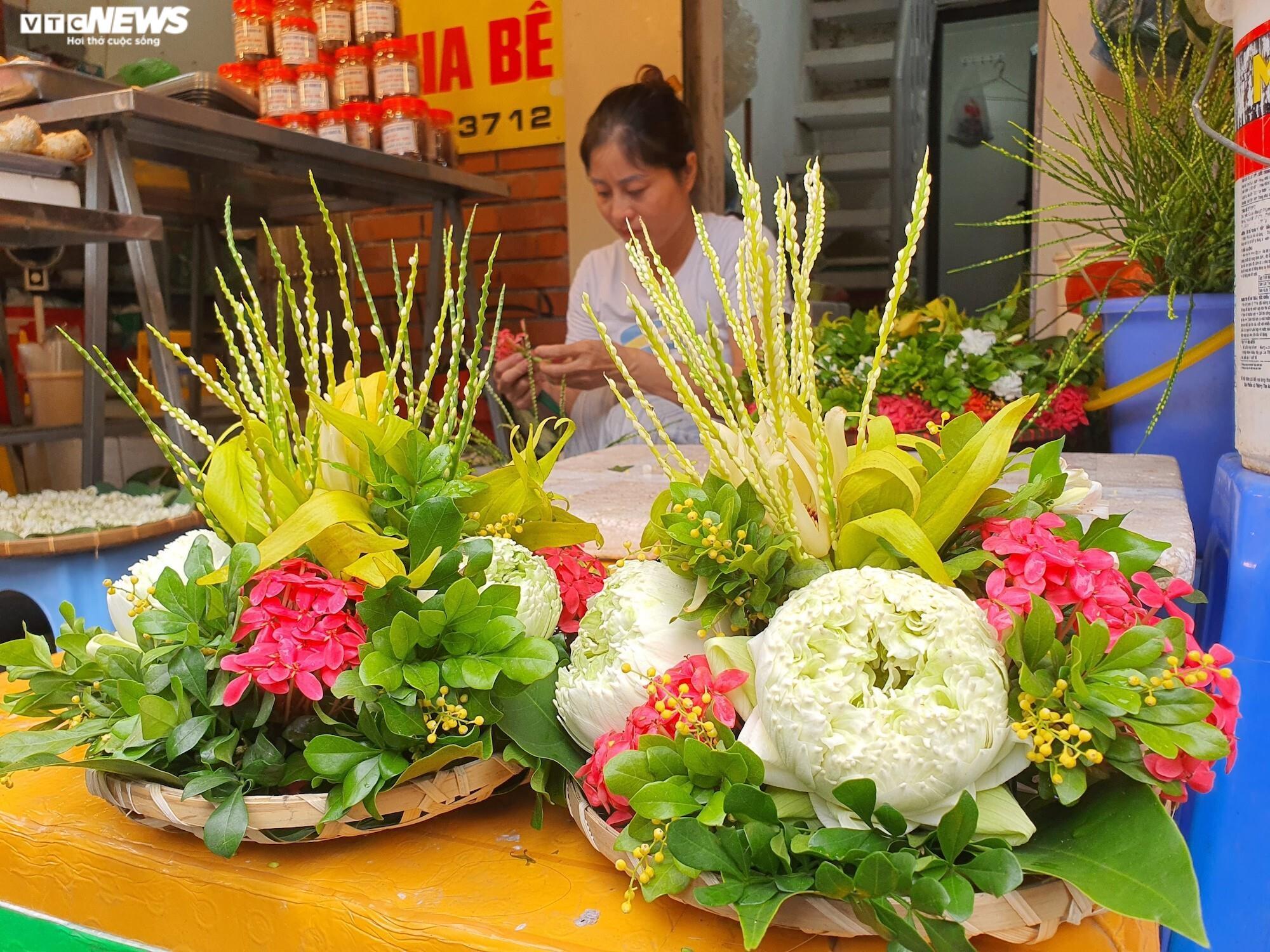 Ngoài bán đồ ăn sẵn, tại đây các tiểu thương còn bán những mẹt hoa tươi đầy màu sắc với giá 150.000 đồng/mẹt. Chủ một hàng hoa cho biết, cận ngày Rằm tháng 7, mỗi ngày chị bán được tới 150 - 200 mẹt, thậm chí có hôm còn 