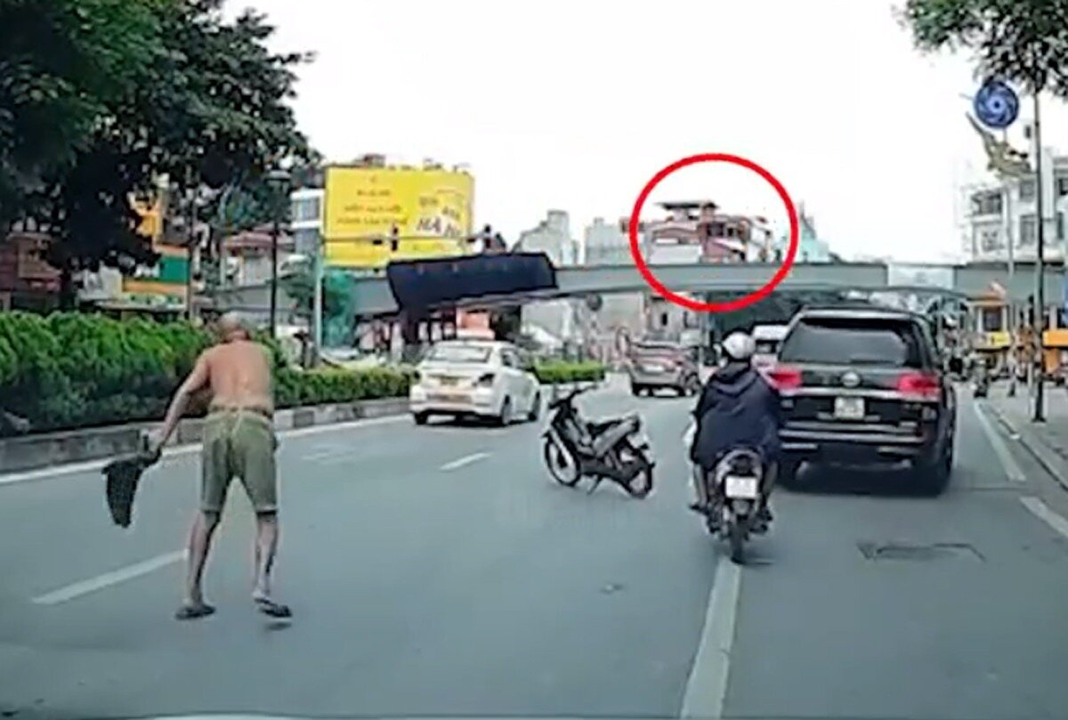 Người đàn ông phi dao vào ô tô đang chạy trên đường. (Ảnh: Ảnh cắt từ clip)
