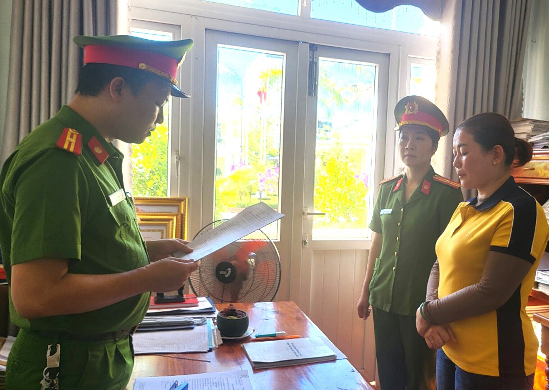 Lực lượng chức năng đọc quyết định khởi tố Trịnh Thị Hoa. (Ảnh: C.A)