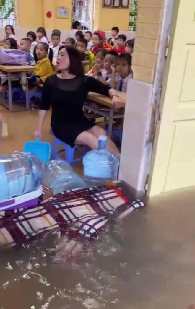 Hình ảnh cô giáo trường Tiểu học Phú Lương II cầm hốt rác nhựa để tát nước từ trong lớp ra ngoài được chia sẻ rộng rãi trên mạng xã hội. (Ảnh chụp màn hình)
