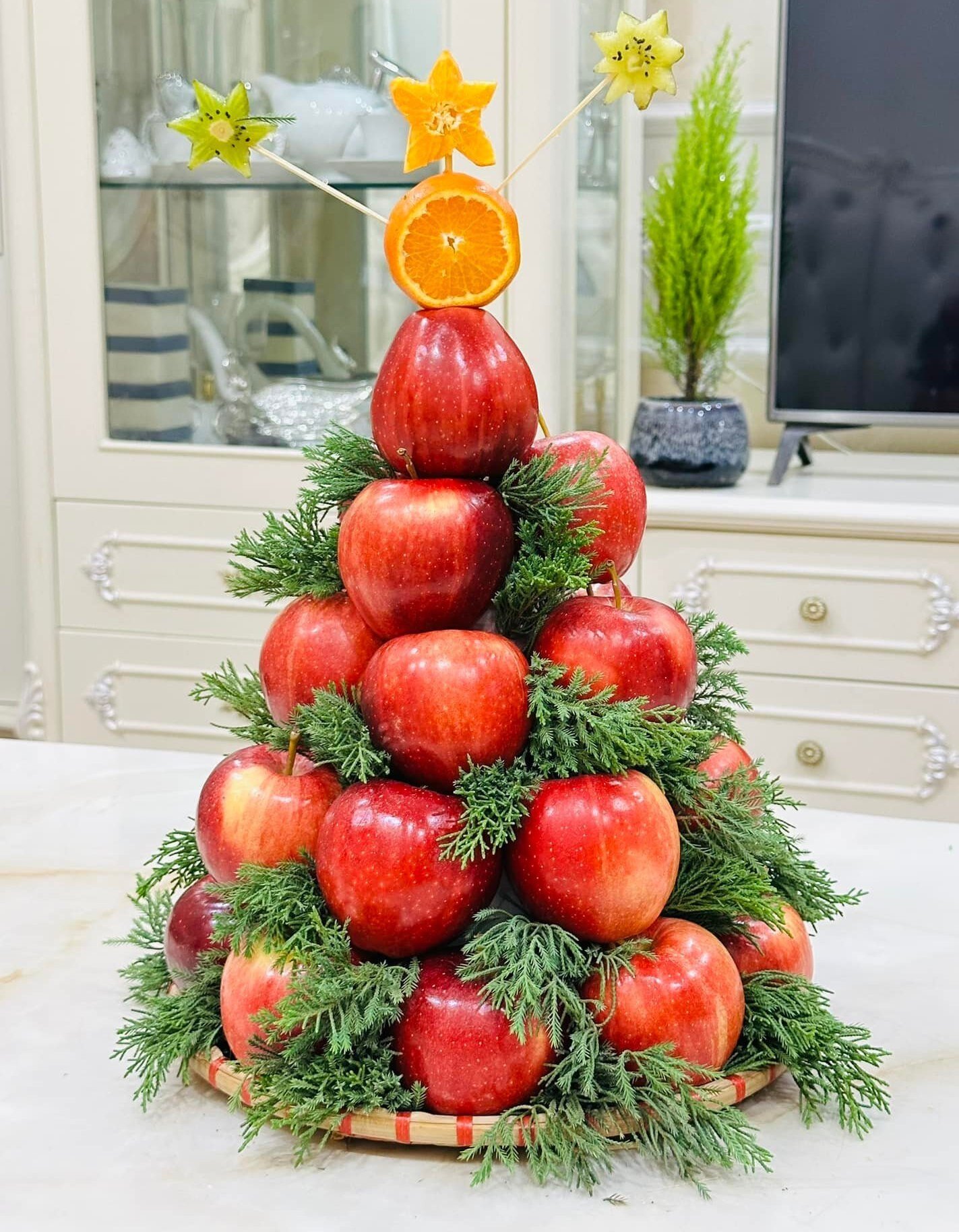 Không cần cắt tỉa hay tạo hình, bà mẹ này để nguyên những quả táo mà vẫn có thể dựng thành công cây thông Noel đẹp lạ. Cây thông này sẽ chơi được lâu hơn so với những cây thông từ trái cây cắt tỉa. (Ảnh: Kim JinHua)