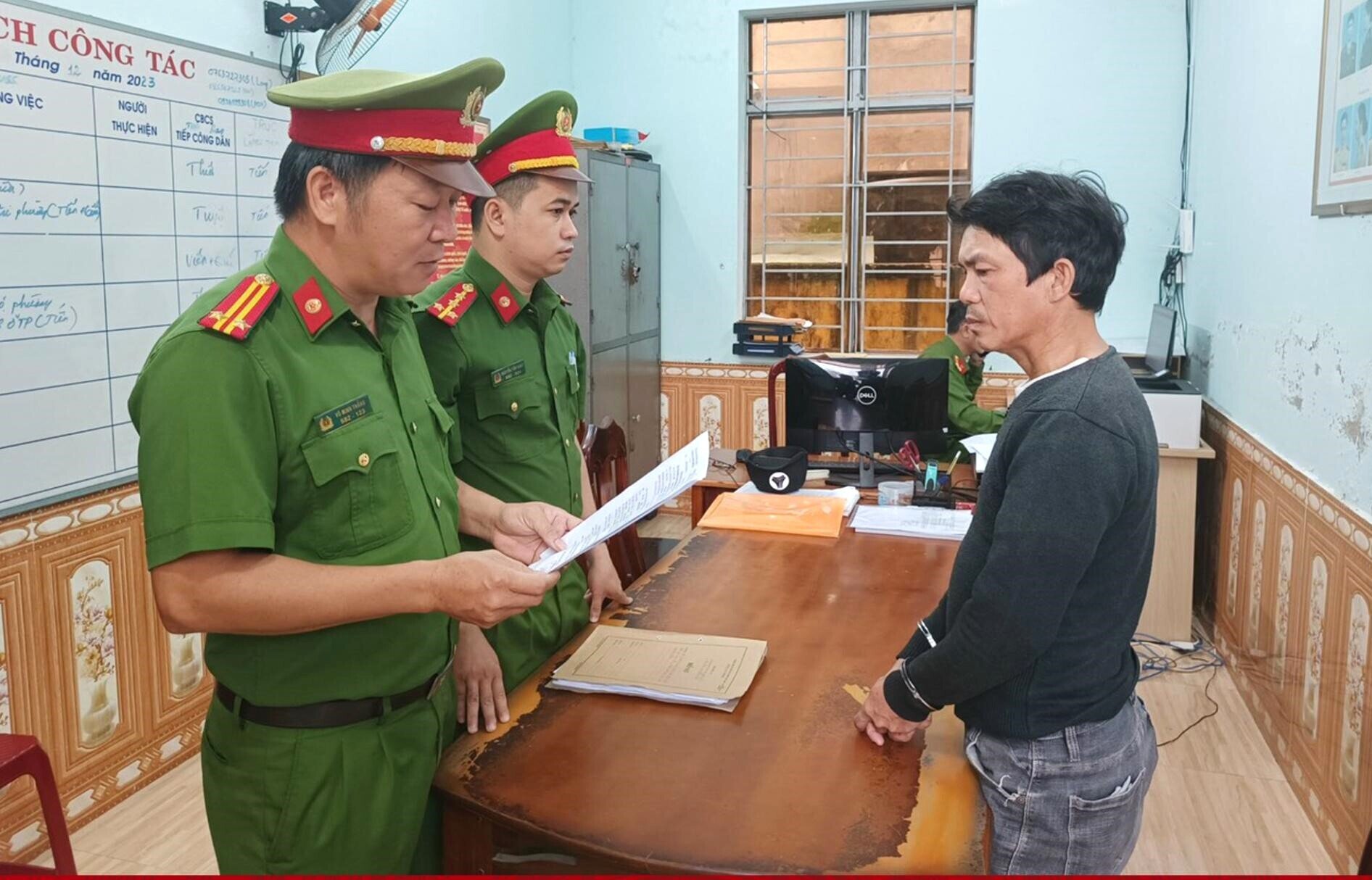 Lực lượng chức năng đọc quyết định khởi tố Huỳnh Châu. (Ảnh: C.A)