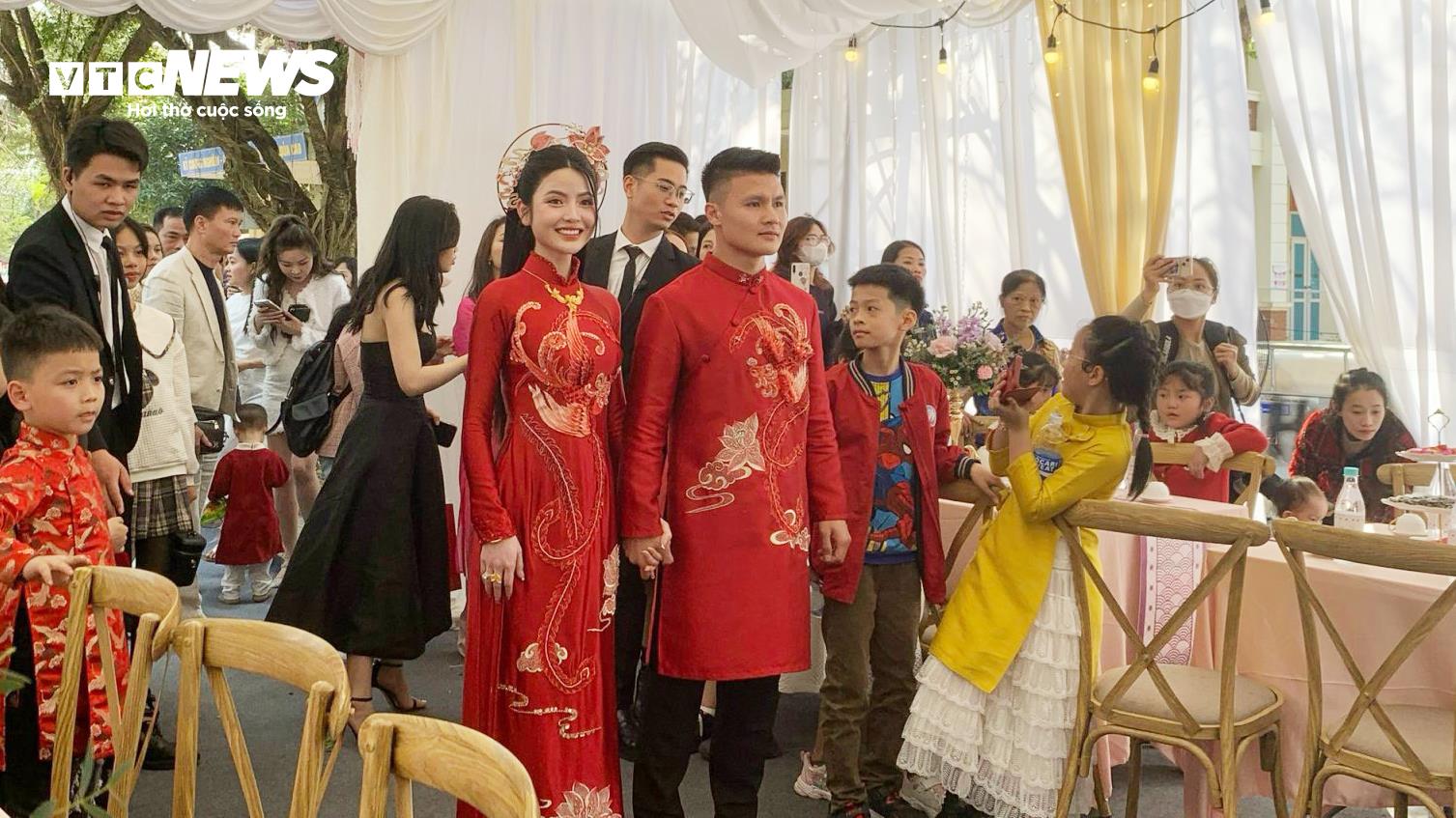 Cặp đôi mặc áo dài đỏ được thiết kế riêng bởi một nhà may nổi tiếng, từng làm việc với nhiều ngôi sao trong giới giải trí cũng như cầu thủ. (Ảnh: Hương Mơ)