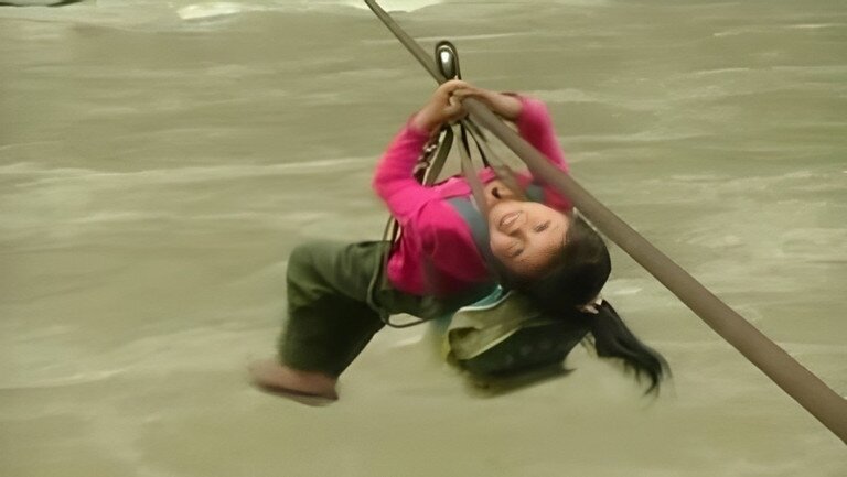 Dư Yên Cáp băng qua sông Nộ Giang bằng dây cáp tạm thời để đến trường.