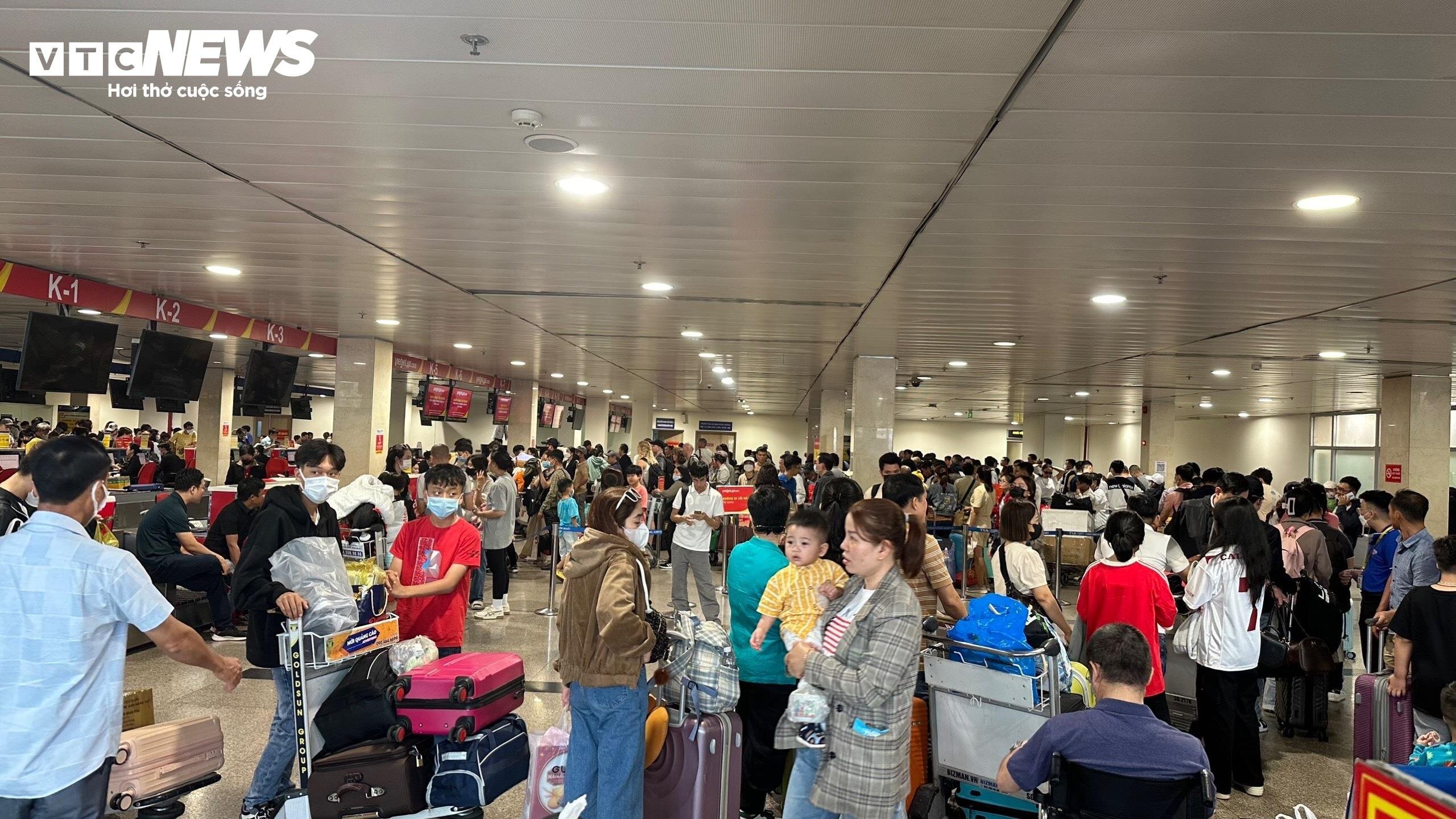 Hành khách đứng chen chúc nhau tại sân bay Tân Sơn Nhất trong những ngày cận Tết Nguyên đán 2024.