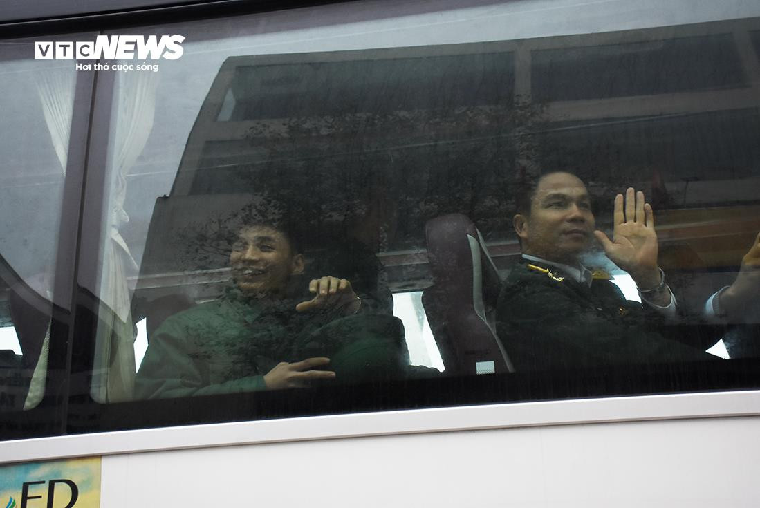 Phía sau tấm kính mờ hơi nước, tân binh nở nụ cười chào người thân.