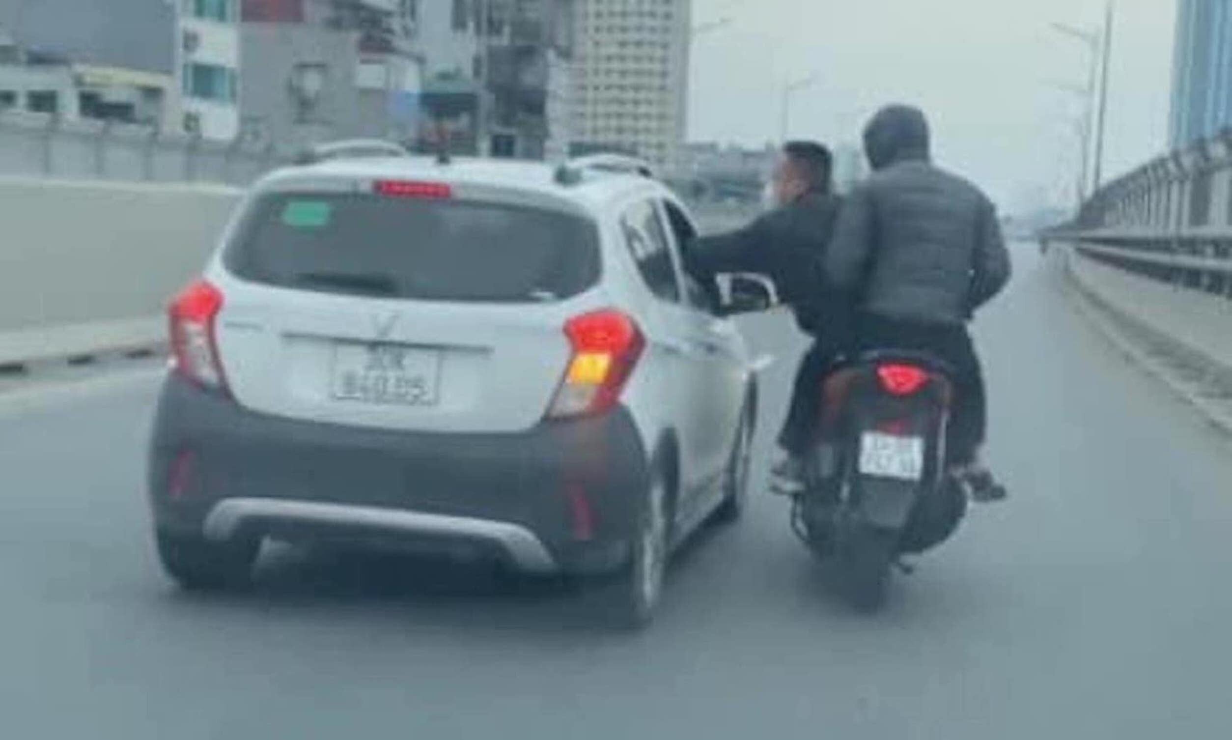 Hai người đi xe máy xô xát với người trên ô tô. (Ảnh cắt từ clip)
